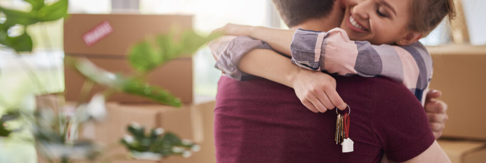 Happy couple with keys of new apartment